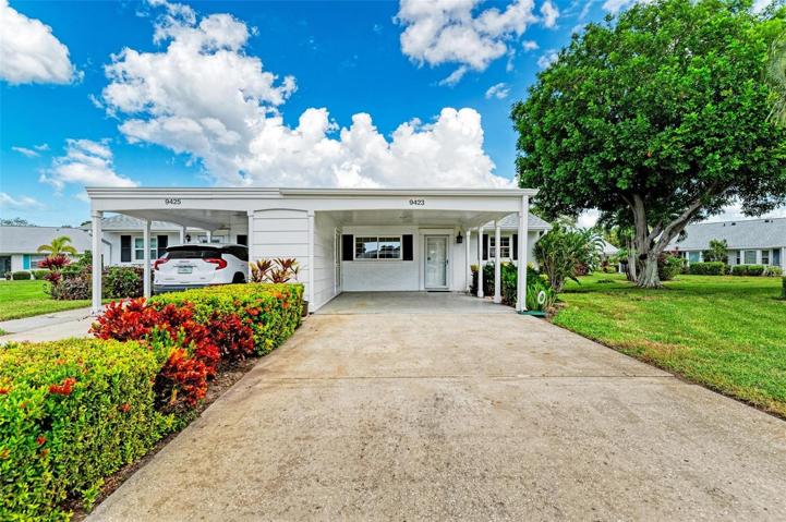 Exterior of Villa has wide driveway with epoxy finish under carport.  Large Storage Room on the left.
