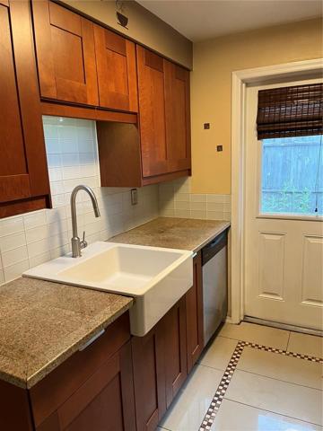 The kitchen has a nice farmers sink and a door to the backyard