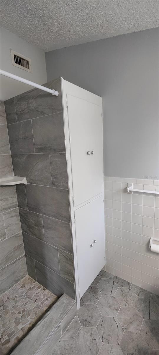 Second floor master bathroom has a large linen closet with four doors and deep shelves for all your sheets, towels and toiletries.   New tile flooring in bathroom and shower.  Tiled shower walls has a convieant soap dish mounted in the corner.