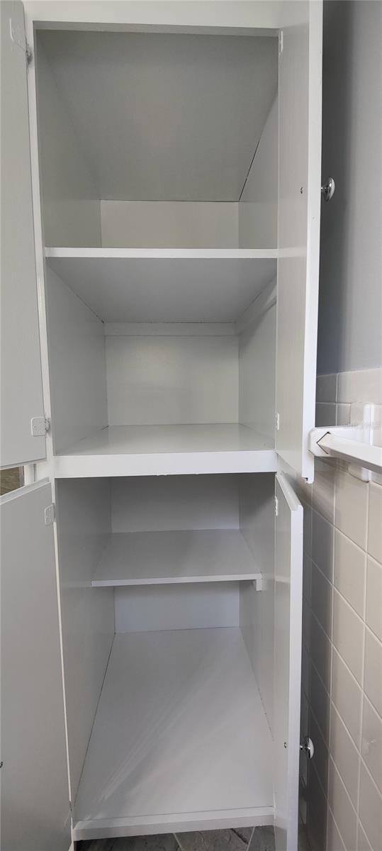 Second floor master bathroom linen closet has deep shelves and four doors.