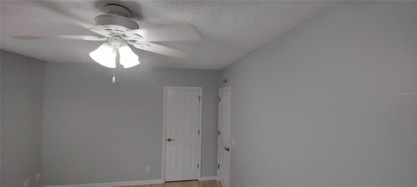 First floor master bedroom has a comfortable ceiling fan/light. Door to master bathroom straight ahead.  Exit to hall on right.