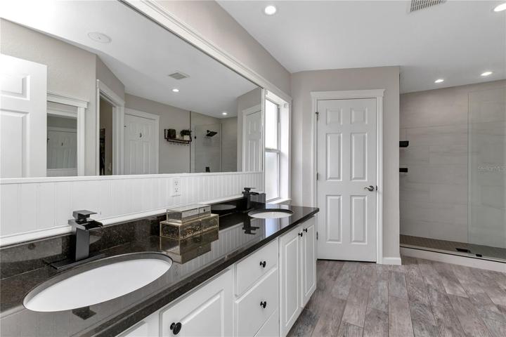 Double vanity in primary bathroom with natural light from window