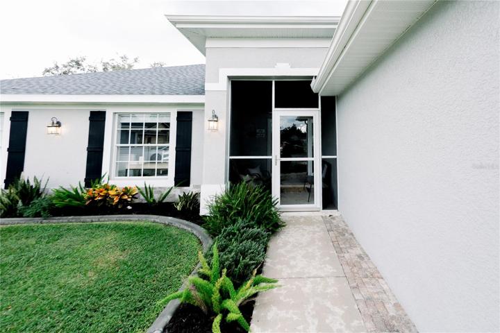 Tropical, low-maintenance landscaping, new mulch, and screened porch with storm door
