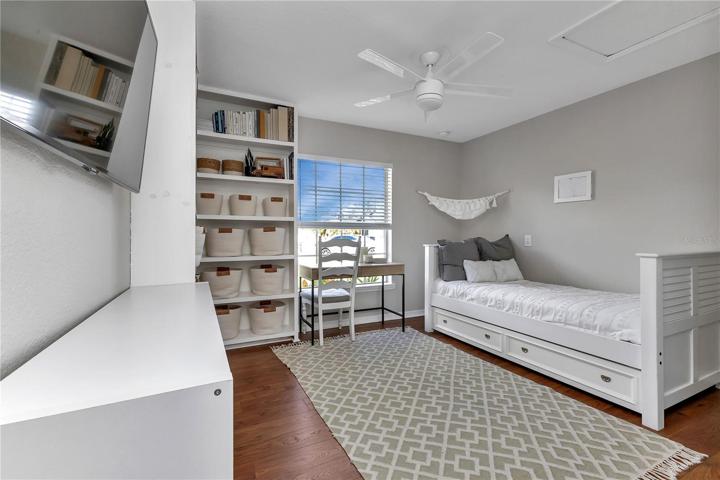 4th bedroom with built-in corner bookshelves