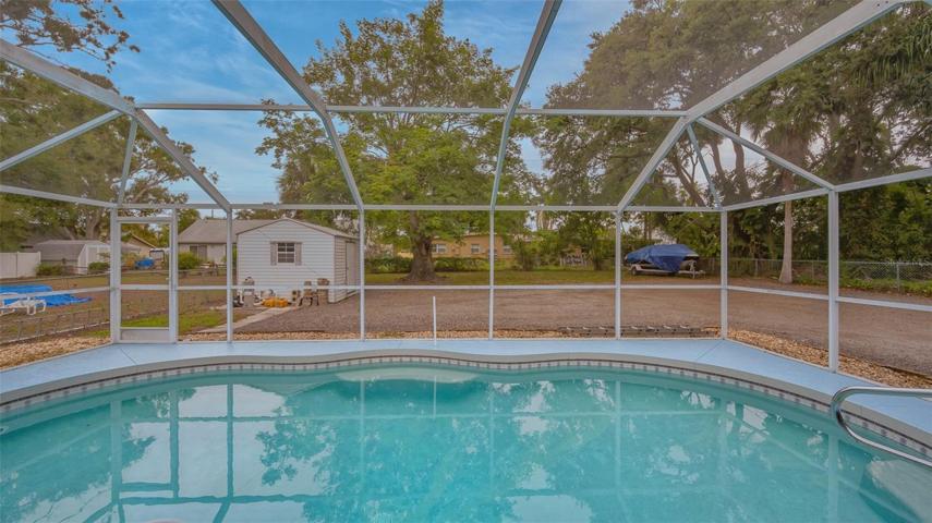 Caged pool, spacious rear fenced yard and shed