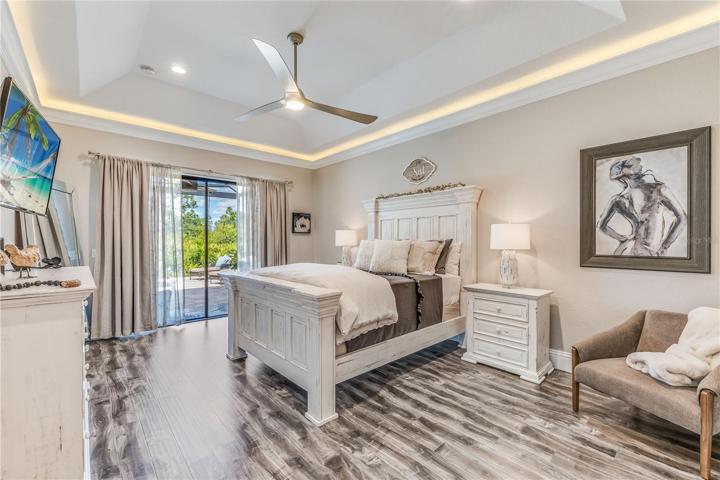 Master Bedroom With Tray Ceilings and Slider To A Private Sitting Area On The Lanai