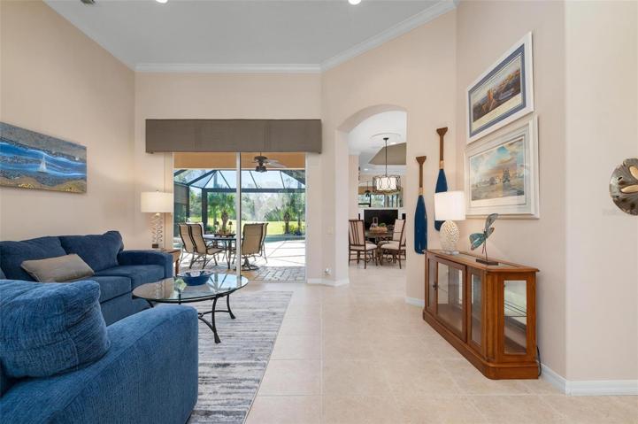 Upon entry. Living room with volume ceiling, crown molding and tile throughout common areas