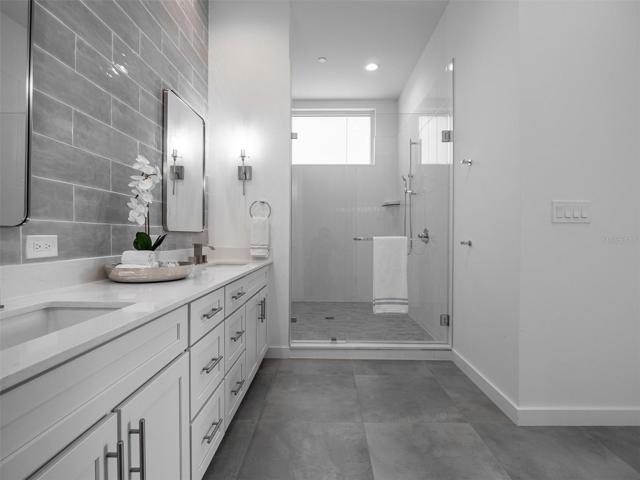 Inviting Primary suite bathroom with double vanities and large shower