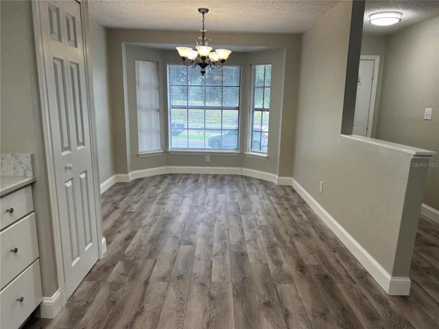 kitchen featuring new laminate flooring, freshly painted, pantry and eating space