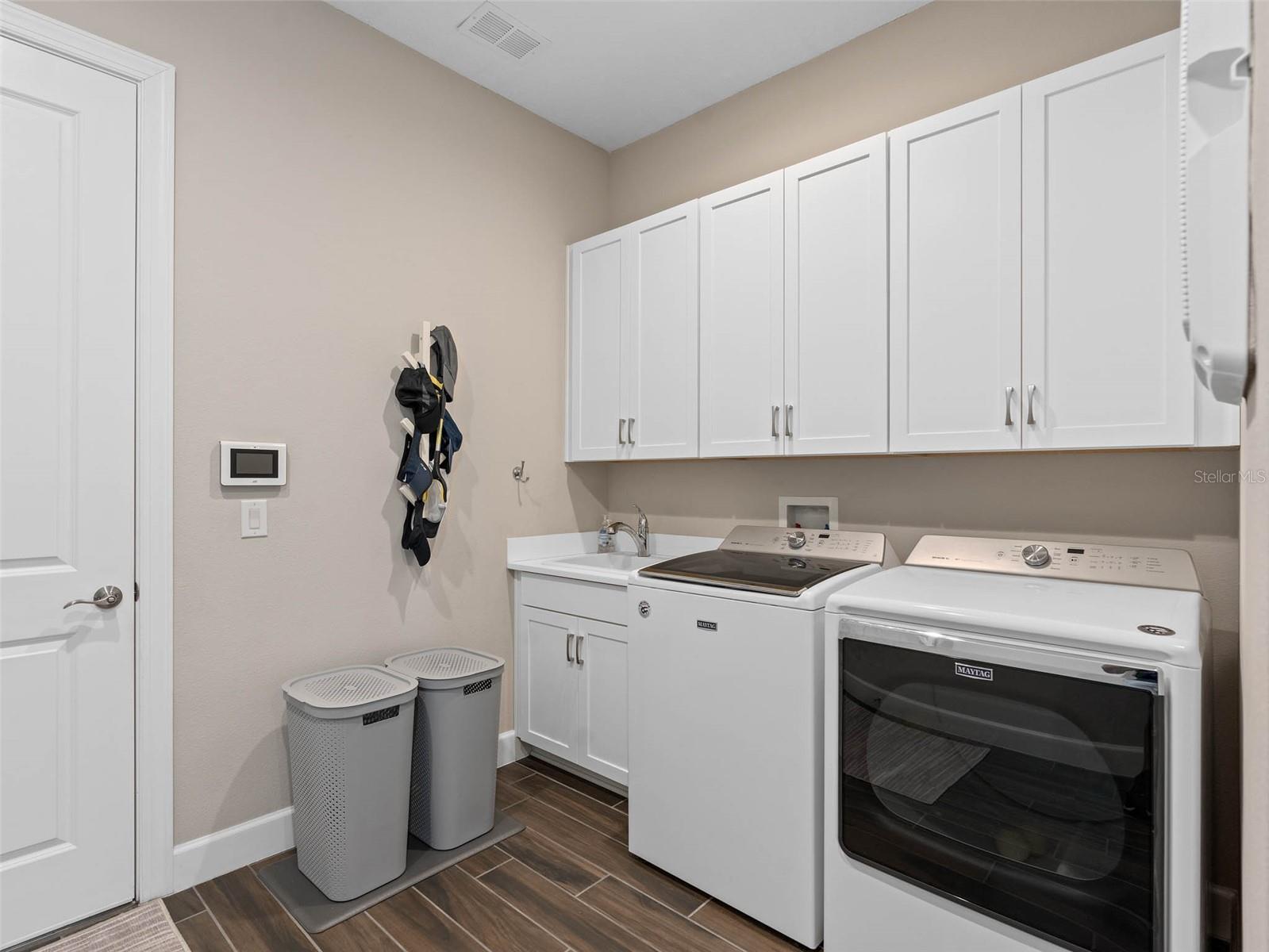 Laundry Room offers the convenience of a Sink and Cabinetry. The Washer and Dryer convey with the purchase.