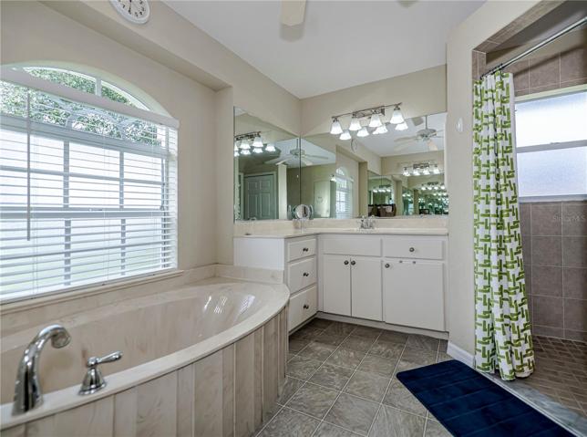 Two vanity sinks, tub, and separate shower