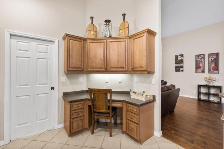 Gourmet Kitchen featuring wood cabinetry, stainless steel appliances, a built-in work station, and large breakfast bar.