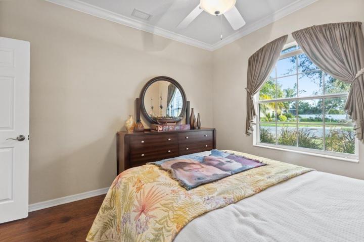 Guest bedroom #2 featuring engineered hardwood, crown molding, and a built-in closet