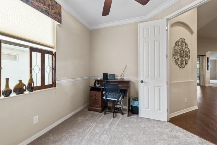 Office/ Den located off the living room featuring crown molding and new carpet.