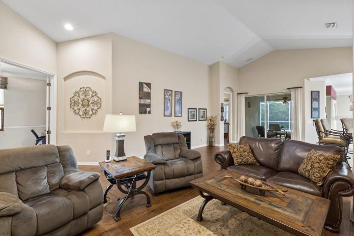 Living room featuring engineered hardwood, cathedral ceilings, and built-in accents.