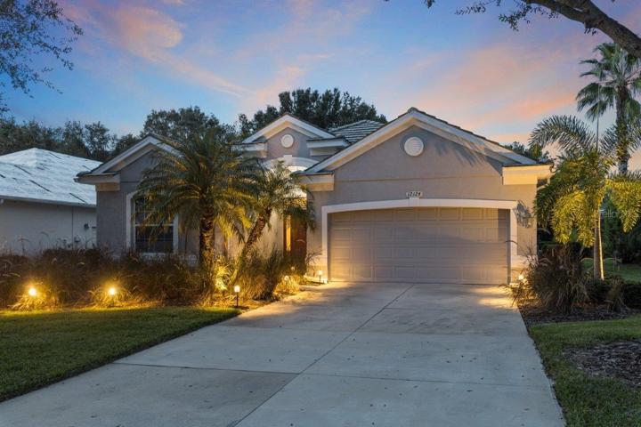 Front Elevation showing the extensive landscaping, landscape lighting, and oversized driveway.