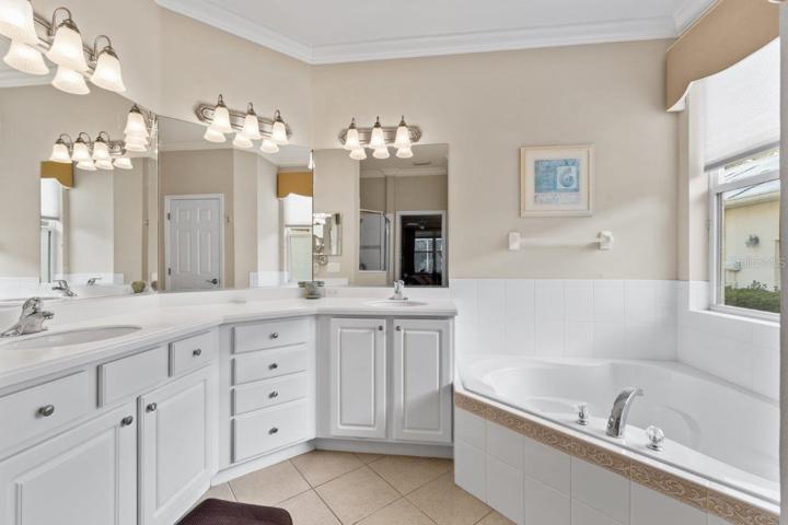 Owners ensuite bathroom featuring dual sinks, a garden tub, and walk-in shower.