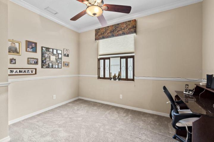 Office/ Den located off the living room featuring crown molding and new carpet.