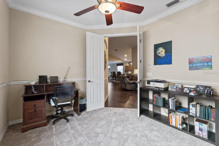 Office/ Den located off the living room featuring crown molding and new carpet.