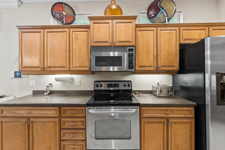Gourmet Kitchen featuring wood cabinetry, stainless steel appliances, a built-in work station, and large breakfast bar.