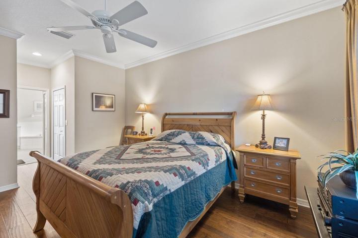 Owners suite featuring engineered hard wood, crown molding, two walk-in closets, and an ensuite bathroom.