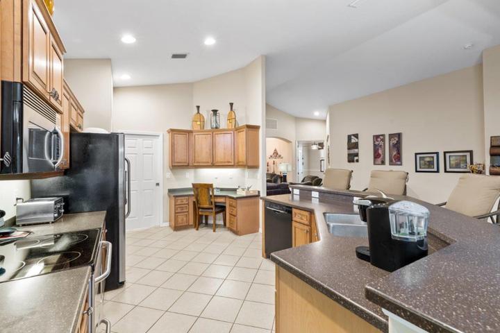 Gourmet Kitchen featuring wood cabinetry, stainless steel appliances, a built-in work station, and large breakfast bar.