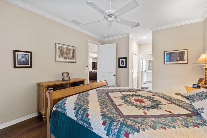 Owners suite featuring engineered hard wood, crown molding, two walk-in closets, and an ensuite bathroom.