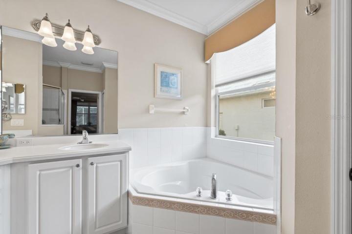 Owners ensuite bathroom featuring dual sinks, a garden tub, and walk-in shower.