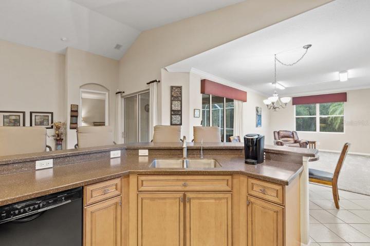 Gourmet Kitchen featuring wood cabinetry, stainless steel appliances, a built-in work station, and large breakfast bar.