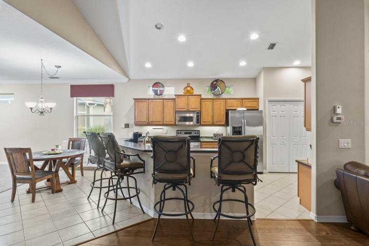Gourmet Kitchen featuring wood cabinetry, stainless steel appliances, a built-in work station, and large breakfast bar.
