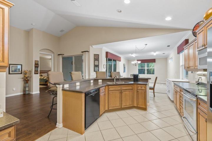 Gourmet Kitchen featuring wood cabinetry, stainless steel appliances, a built-in work station, and large breakfast bar.