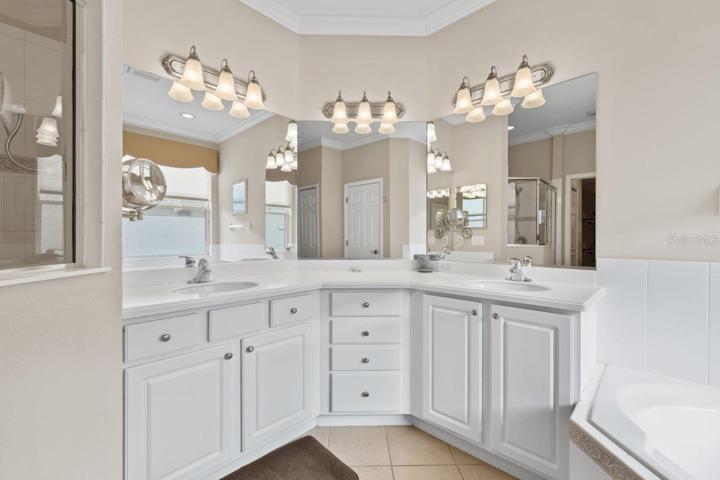 Owners ensuite bathroom featuring dual sinks, a garden tub, and walk-in shower.