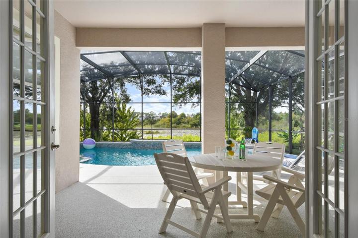Your outdoor oasis awaits through French doors to an inviting covered lanai, fully renovated deck and pool area complete with peaceful views of the Caywood Pond.