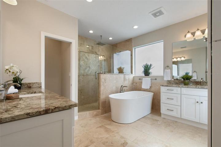 Spa like master bath with separate vanities, soaking tub with bubblers and lighting, stone counters and walk in shower featuring rainhead water flow........ a dream come true.