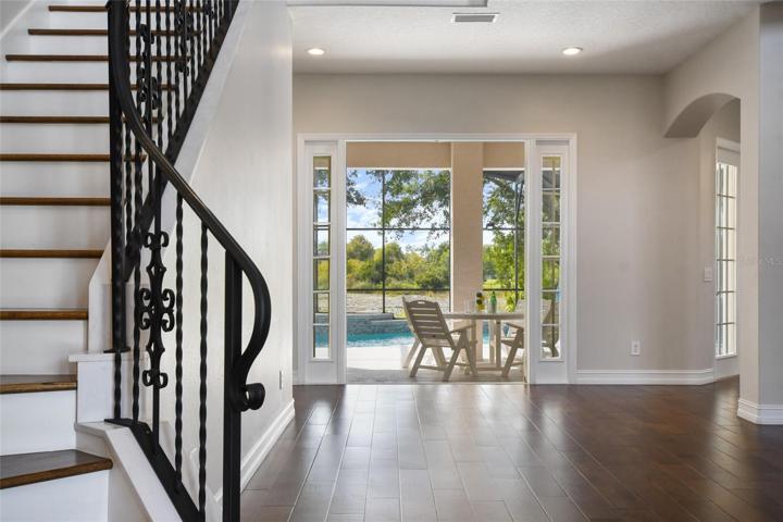 While enjoying the outdoor view towards the rear of living room you can access the flex room, to the right, for use as an office, gym, or guest quarters with views of th pool. Immediately adjacent to the flex room is a full bath.