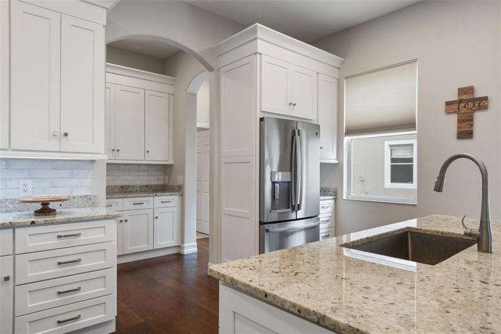 From the drop zone access the gourmet kitchen, a chefs dream, featuring a massive island with a deep sink for easy clean up.