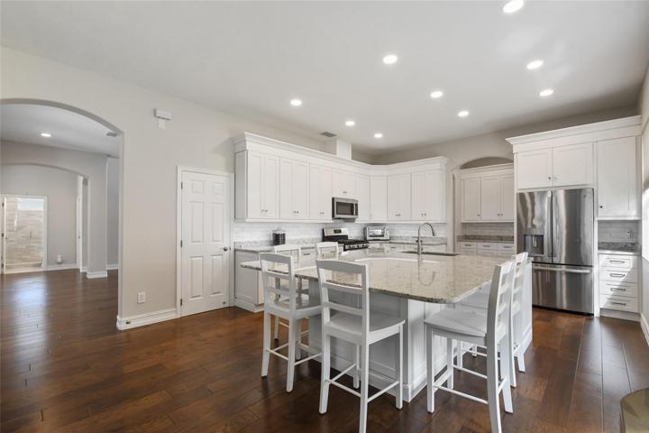 Oversized kitchen island with seating for the entire family and an abundance of lighting with the new can lights.