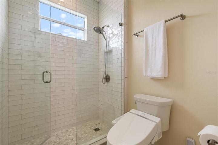 Note the charming subway tile finished to the ceiling in the shower, TOTO toilet, new plumbing fixtures and bright natural feel of this guest bath on the main floor.