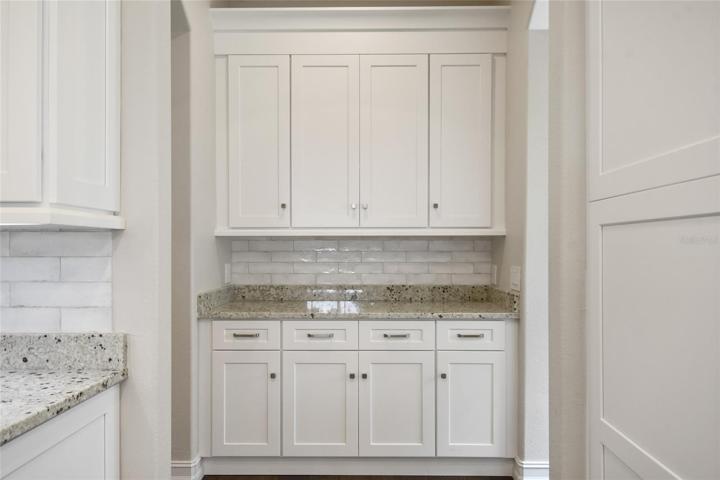 A full view of the drop zone with a beautiful cabinetry, stone counter and plenty of storage.