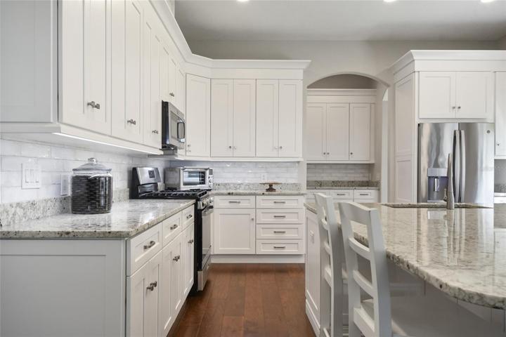 Note the under cabinet lighting, engineered wood flooring, and fresh interior paint.