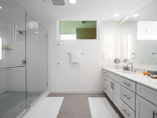 En-suite primary bathroom with dual sinks and walk in shower with double shower heads