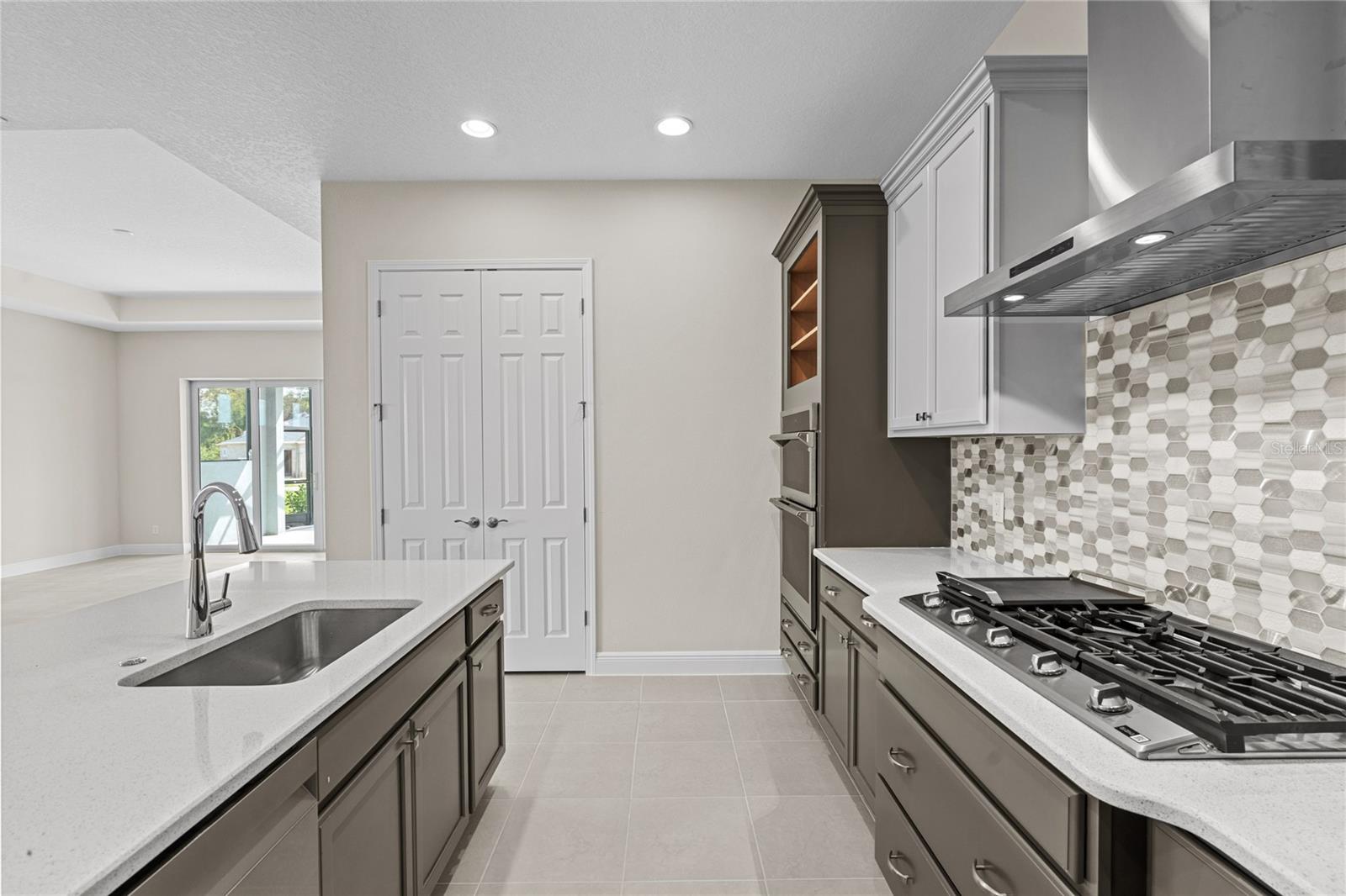 Kitchen. Gas cooktop, chimney hood, refrigerator.