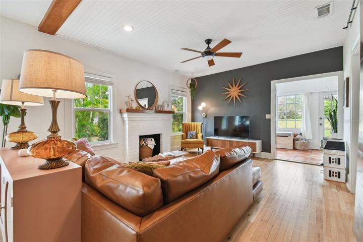 Large, comfortable living room, featuring high wainscoted ceilings accented with wood beams and recessed lighting.
