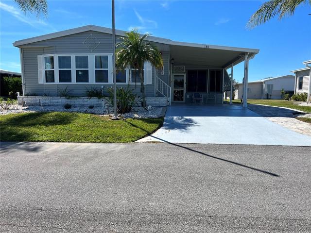 180 front view, tandem parking driveway with carport for one car plus paver golf cart parking area.