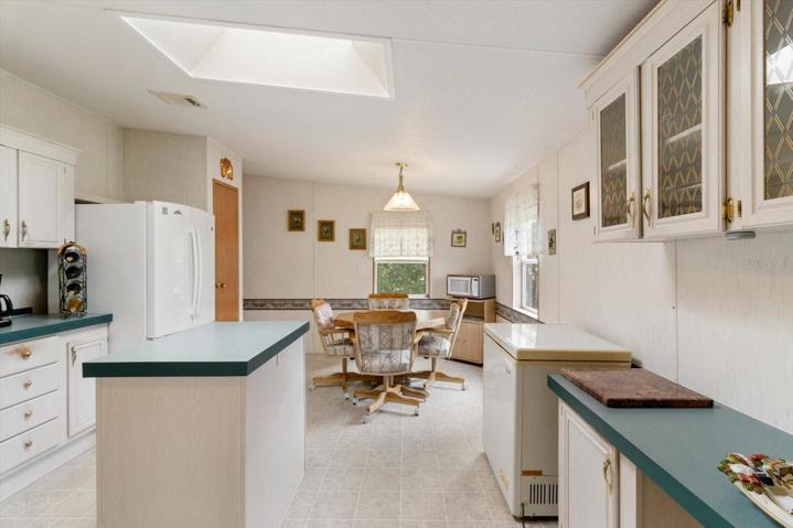Kitchen is flooded with natural light from the skylight and 2 windows and has an eat-in area and convenient access to a laundry room