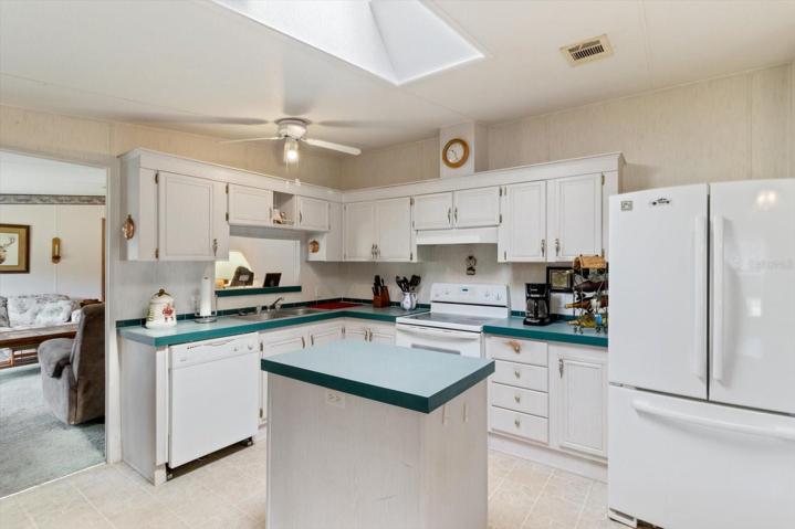 This large kitchen with skylight and central island is in the heart of this home with direct access to the living room