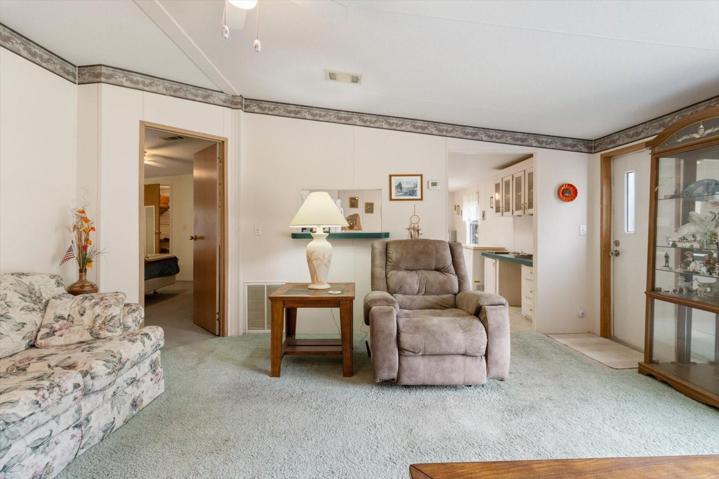 Living room looking into kitchen entrance and doorway to primary bedroom with ensuite