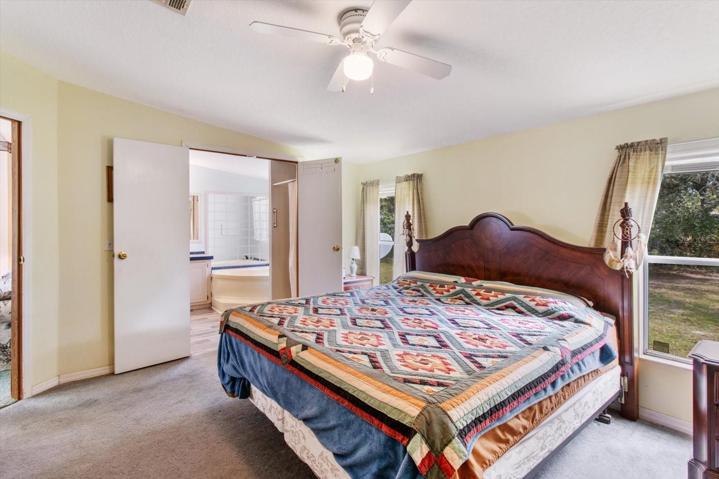 Primary Bedroom 15 x 13 has a walk-in closet and en-suite bathroom, vaulted ceiling and fan, and overlooks the backyard.