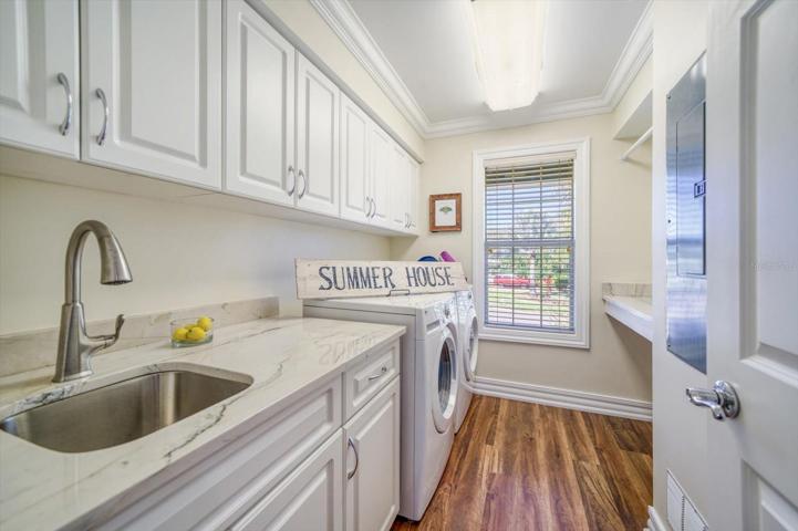 Laundry room with separate sink, abundant storage, hanging area and laundry folding counter. Everything one needs!