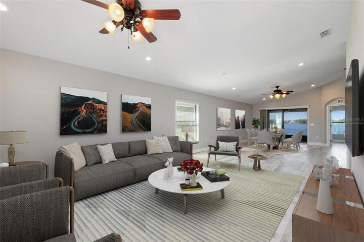 This photo has been virtually staged. As you step inside, you'll be greeted by an open floor plan adorned with vaulted ceilings that seamlessly blends your living, dining, and kitchen areas.